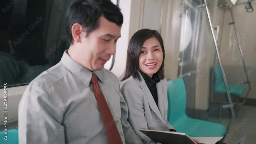 Asian Businessman talking with businesswoman on the skytrain or subway their way to working transportation people lifestyle concept. Asian Businessman talking with businesswoman on the skytrain or subway their way to working transportation people lifestyle concept.