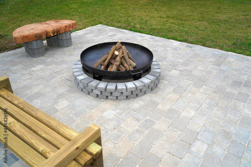 Iron fire pit and firewoods ready to burn on fireplace in a garden