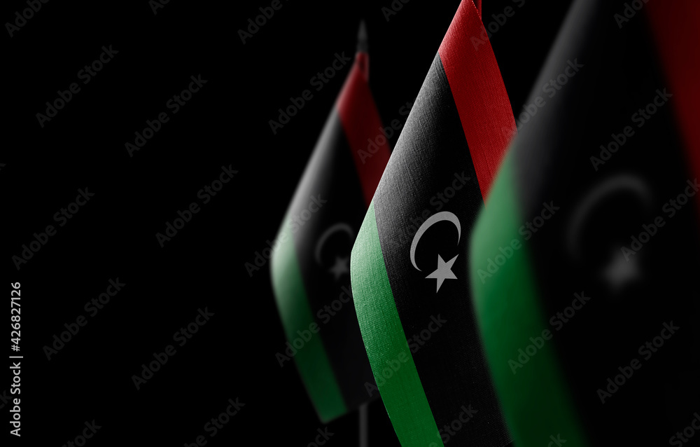 Small national flags of the Libya on a black background