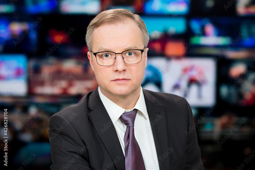 An anchorman reporting live breaking news sitting in Tv studio. Background of multiple screens of broadcast control room. Journalism concept An anchorman reporting live breaking news sitting in Tv studio. Background of multiple screens of broadcast control room. Journalism concept