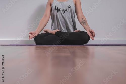 Young woman meditating on yoga mat in studio