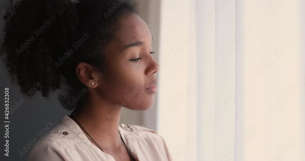 Lost in pleasant thoughts happy young mixed race african woman looking in distance out of window, contemplating beautiful nature or cityscape, enjoying peaceful weekend moment, visualizing future. Lost in pleasant thoughts happy young mixed race african woman looking in distance out of window, contemplating beautiful nature or cityscape, enjoying peaceful weekend moment, visualizing future.