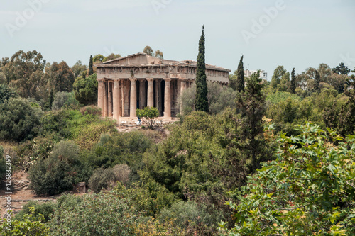 Fotografía Ancient Temple of Hephaestus surrounded by lush summer vegetation in Athens, Gre