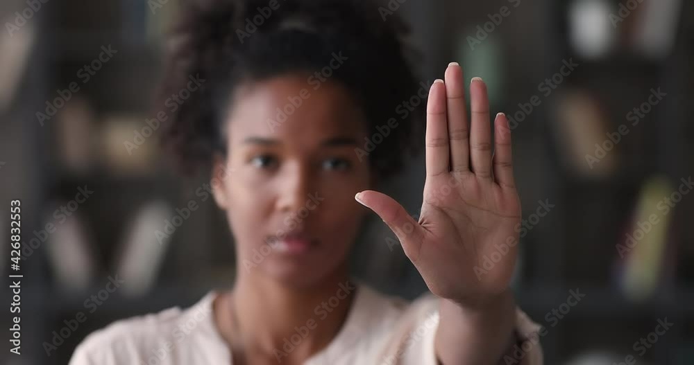 Head shot close up focused serious young african american beautiful woman showing stop sign to camera, protesting against racial or sexual discrimination, denying family abuse or bullying in society.