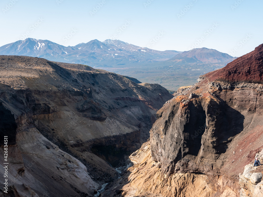 View of the Opasny canyon near the Mutnovsky volcano. The depth of the canyon surprises with its scale and incredible views of the volcanoes. Kamchatka Peninsula, Russia.