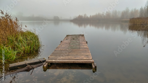 Obraz na płótnie Floating pier on the lake shrouded in fog in autumn w salonie