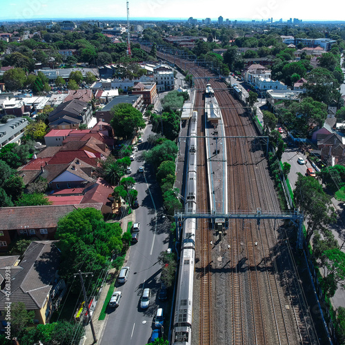 Canvas Print Drone Aerial view of a train tracks in an inner suburb of Sydney with views of r