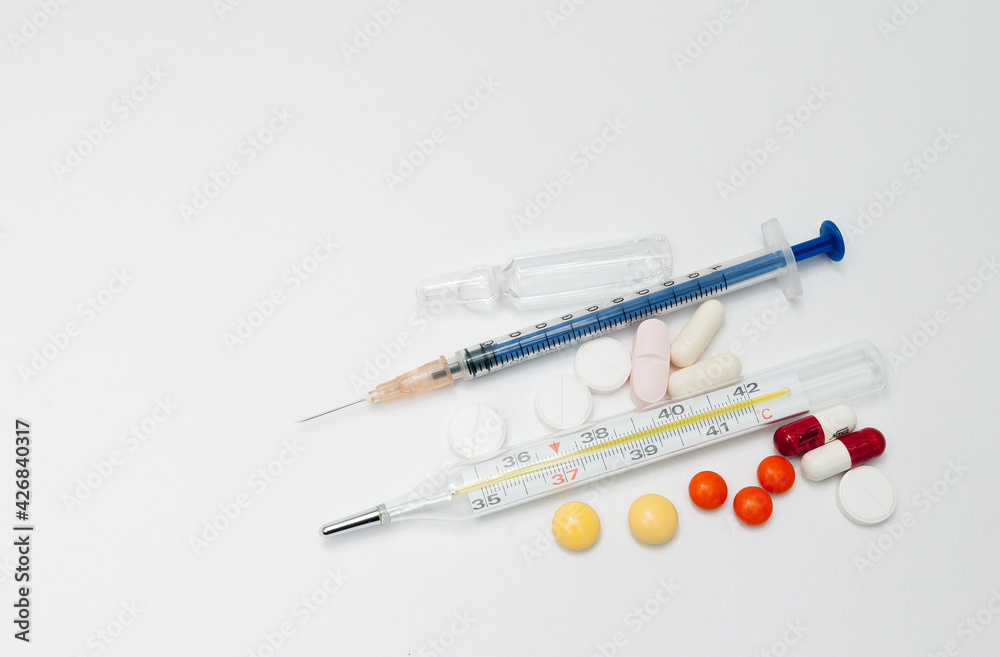 syringe with ampoules and capsules on white background syringe with ampoules and capsules on white background