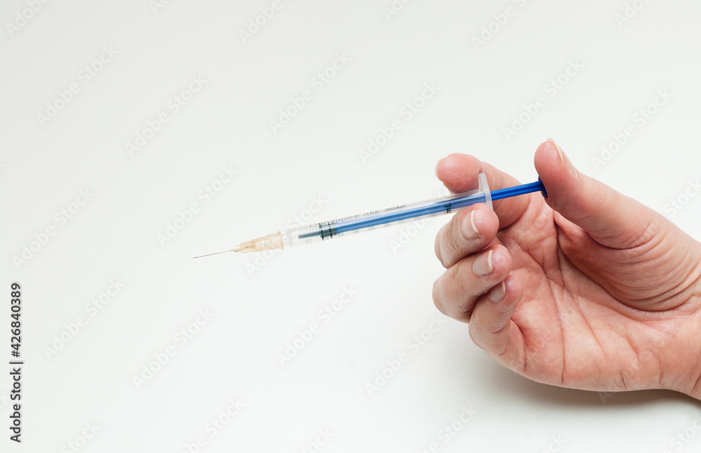 hand with syringe on white background hand with syringe on white background