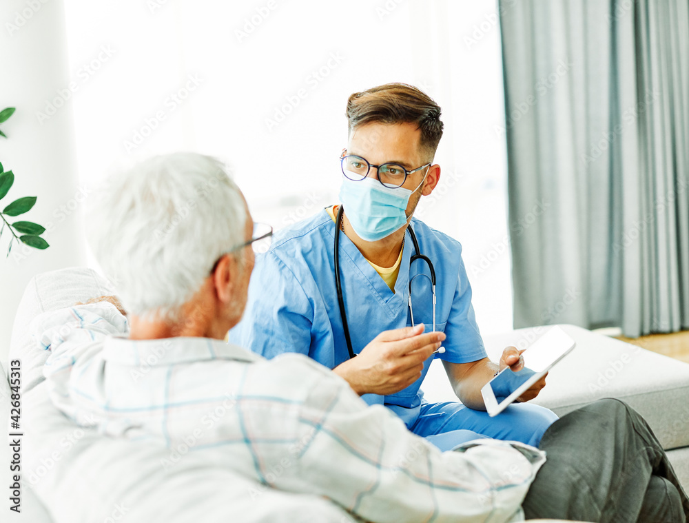 Fototapeta premium nurse doctor senior care caregiver help assistence retirement home tablet computer virus mask corona