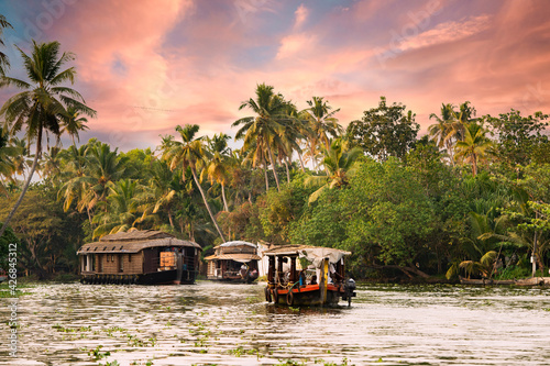 Konstfotografi Stunning view of a boat sailing on the Alleppey's backwaters during a beautiful sunset