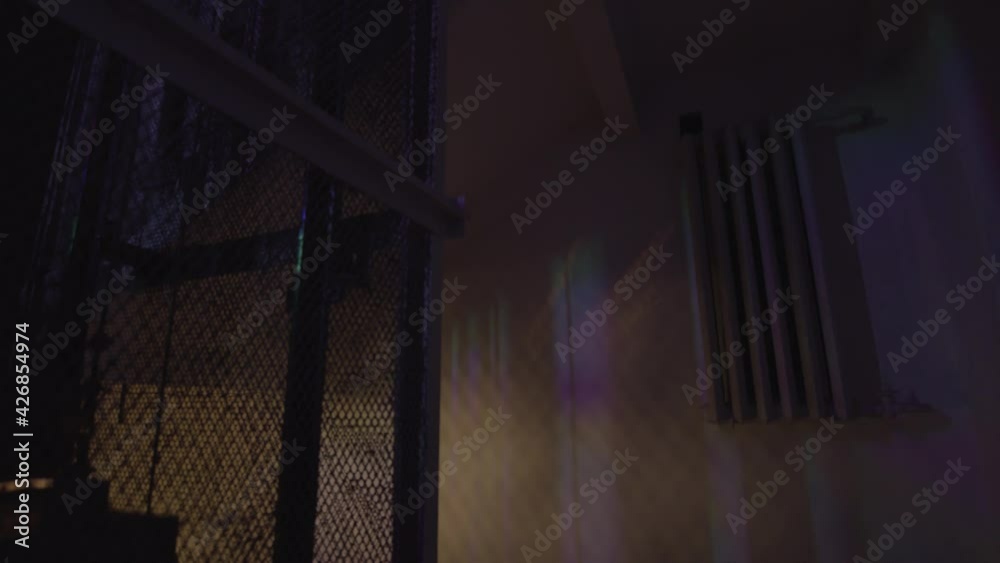 Vintage elevator descending in a dark building with flashing colorful