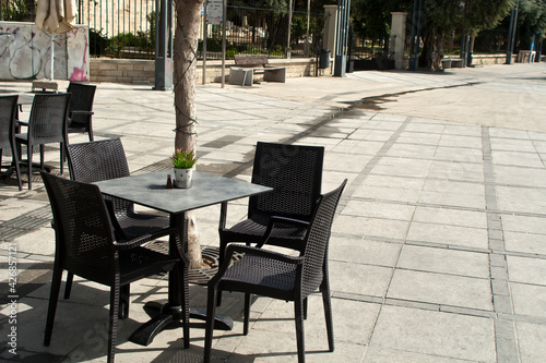 Table and empty chairs at street cafe