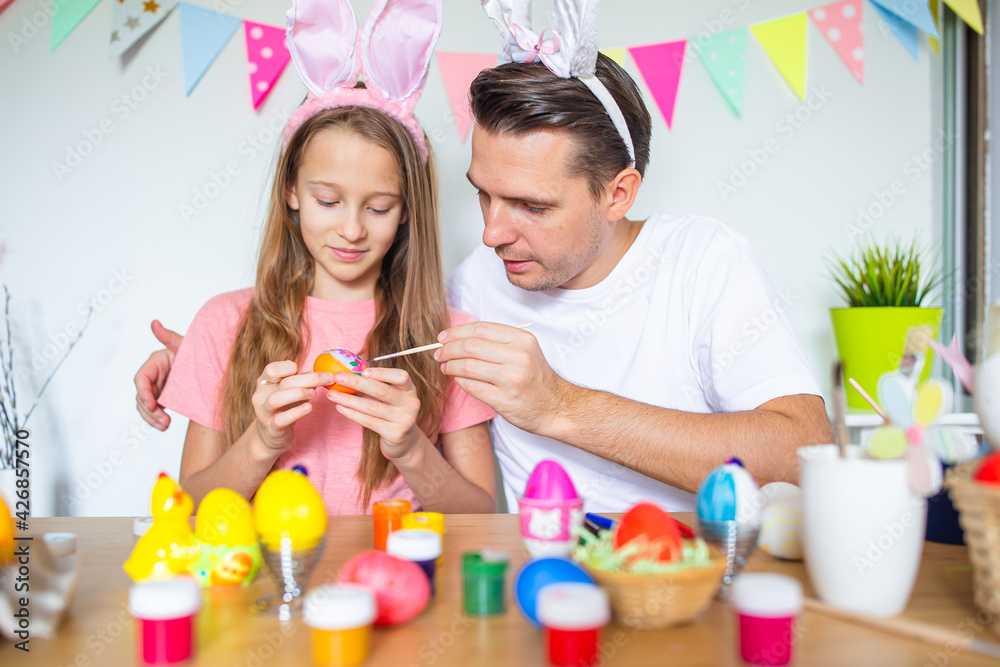 Father and his little daughter painting eggs. Happy family preparing for Easter. Father and his little daughter painting eggs. Happy family preparing for Easter.