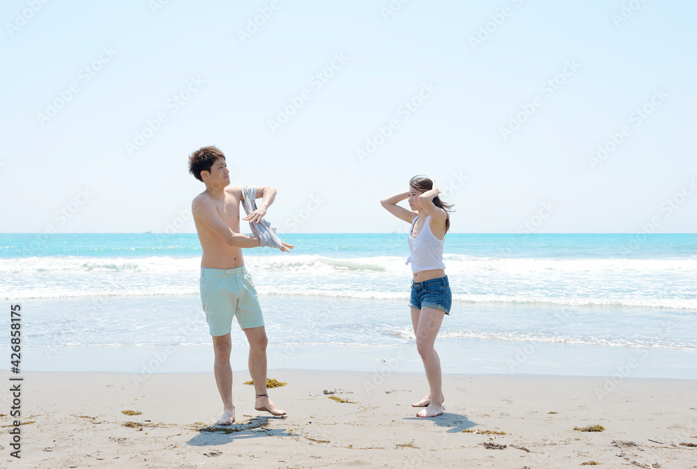 ビーチで遊ぶ若いカップル