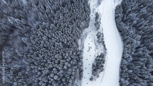 Top view of snowy forest and chairlift on the winter vacation in Carpathian mountains. traveling, concept, drone shot photo