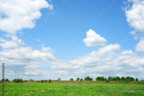 green field and blue clouds sky, rustic landscape. bright summer countryside background