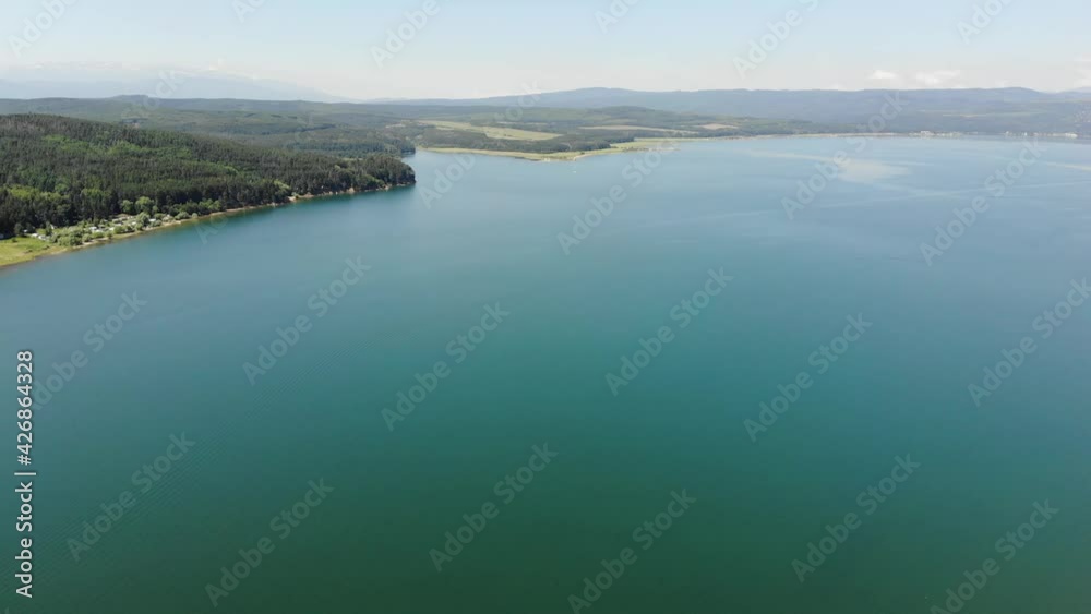 Group of friends enjoyment in the weekend on crowd lake complex. Family vacation with tent in summertime with forest and lagoon. Aerial drone view of Iskar reservoir, remote and scenary place to fun Group of friends enjoyment in the weekend on crowd lake complex. Family vacation with tent in summertime with forest and lagoon. Aerial drone view of Iskar reservoir, remote and scenary place to fun