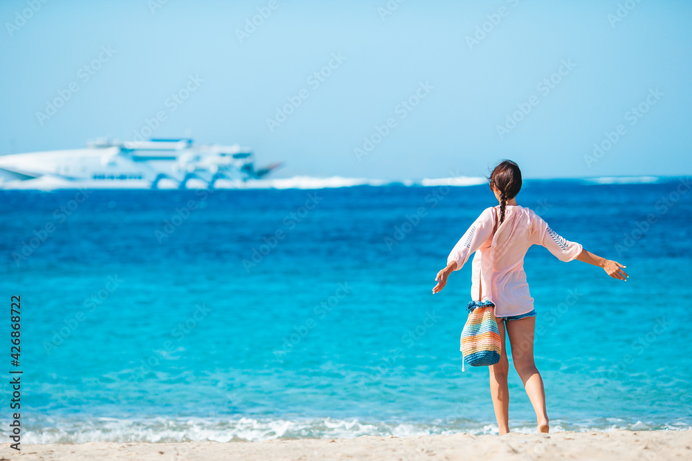 Young beautiful woman on the beach during tropical summer vacation