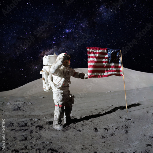 Astronaut holding an American flag on moon surface with the stars and outer space on the background. Elements of this image furnished by NASA.