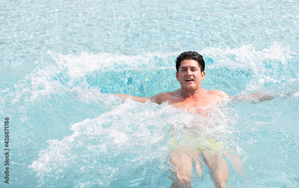 handsome man floating and swimming on the rooftop in pool