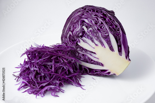 Portion of chopped red cabbage, next to half a head of red cabbage.