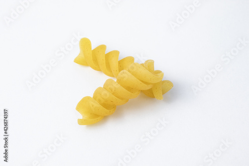 Two units of raw fusilli pasta. Uncooked ingredient of Italian food isolated on white background