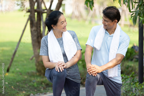 senior asian couple exercising and stretching outdoors, workout in the park