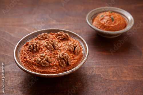 Red peppers spread with walnuts in bowl. Traditional Middle eastern muhammara dish.