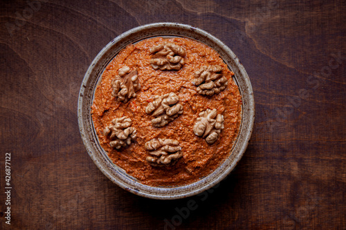 Red peppers spread with walnuts in bowl. Traditional Middle eastern muhammara dish.