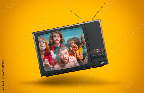 Vintage TV suspended in the air on a yellow background photo