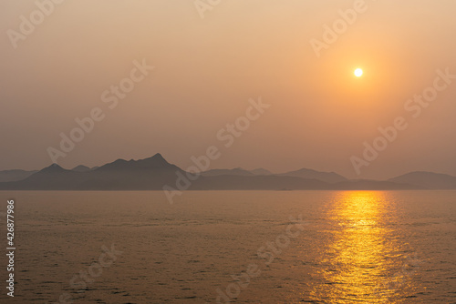 Beautiful sunrise above Chinese sea coast near Xiamen, foggy morning on golden hour.