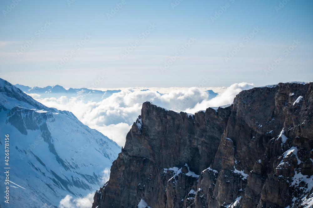 Montagnes à Tignes avec des nuages  au loin et une montagne au premier plan.