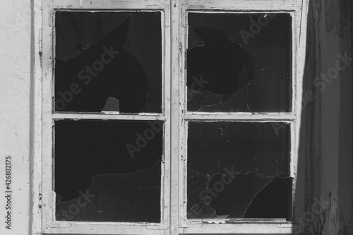 Stare okno wybite szyby opuszczony budynek zdjęcie czarno białe
