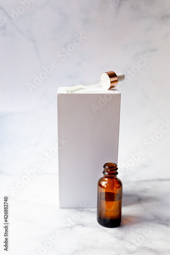 Retinol oil serum oil bottle on isolated marble background. Beauty care concept. photo