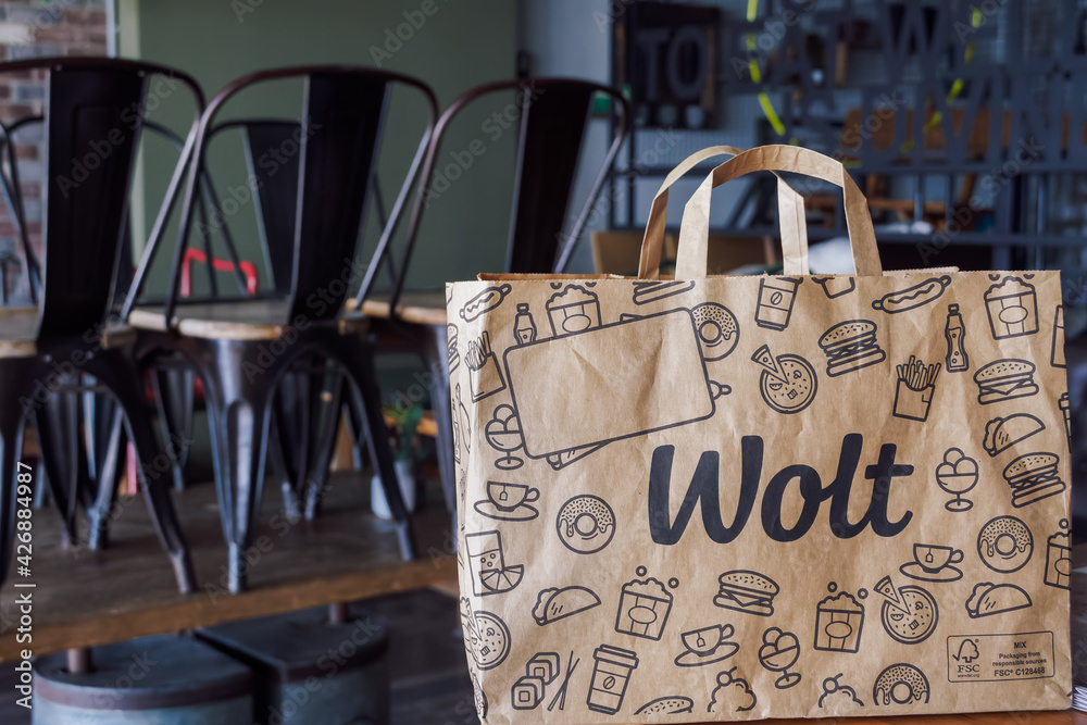 Wolt food delivery bag with company logo, on restaurant. Finish company paper  bag with handle, used by platform courier partners in Thessaloniki, Greece.  Photos | Adobe Stock