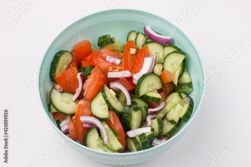 Fresh summer vegetable salad. Vegetarian salad in a bowl with red onion