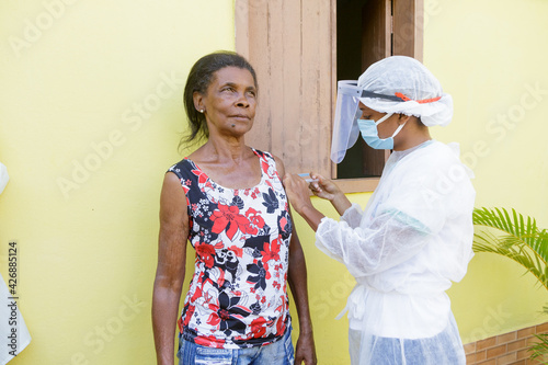 Mulher idosa brasileira é vacinada contra Covid 19, em área rural de Guarani, Minas Gerais, Brasil photo