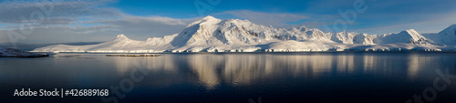 Snow covered Mountains and Icebergs in the Antarctic Peninsula on Antarctica. photo