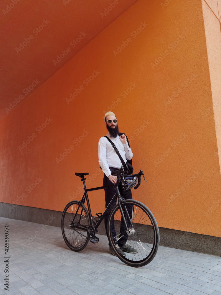 Fototapeta premium A young stylish hipster posing next to his bicycle.