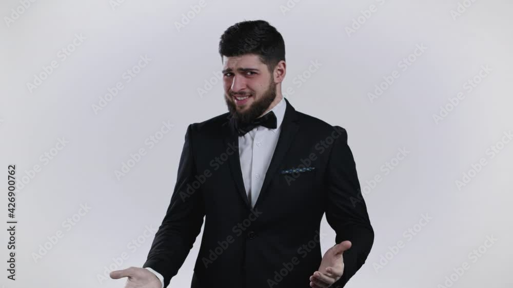 Young man in tuxedo showing gesture of nonsense, not serious. You're kidding, no way. gentlemans reaction to pleasant compliment over white background. Young man in tuxedo showing gesture of nonsense, not serious. You're kidding, no way. gentlemans reaction to pleasant compliment over white background.