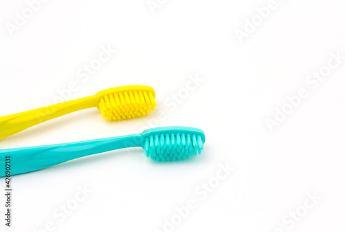 Blue and yellow toothbrushes on a white isolated background.
