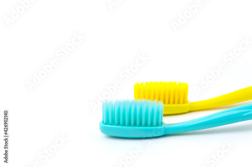 Blue and yellow toothbrushes on a white isolated background.