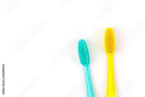 Blue and yellow toothbrushes on a white isolated background.