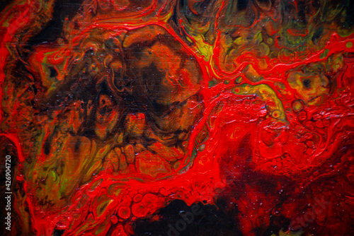 Texture in the style of fluid art. Abstract background with swirling paint effect. Liquid acrylic paint background. Red, black and yellow colors.