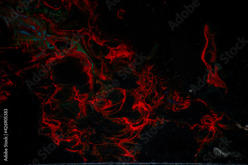Texture in the style of fluid art. Abstract background with swirling paint effect. Liquid acrylic paint background. Black, blue and red colors.