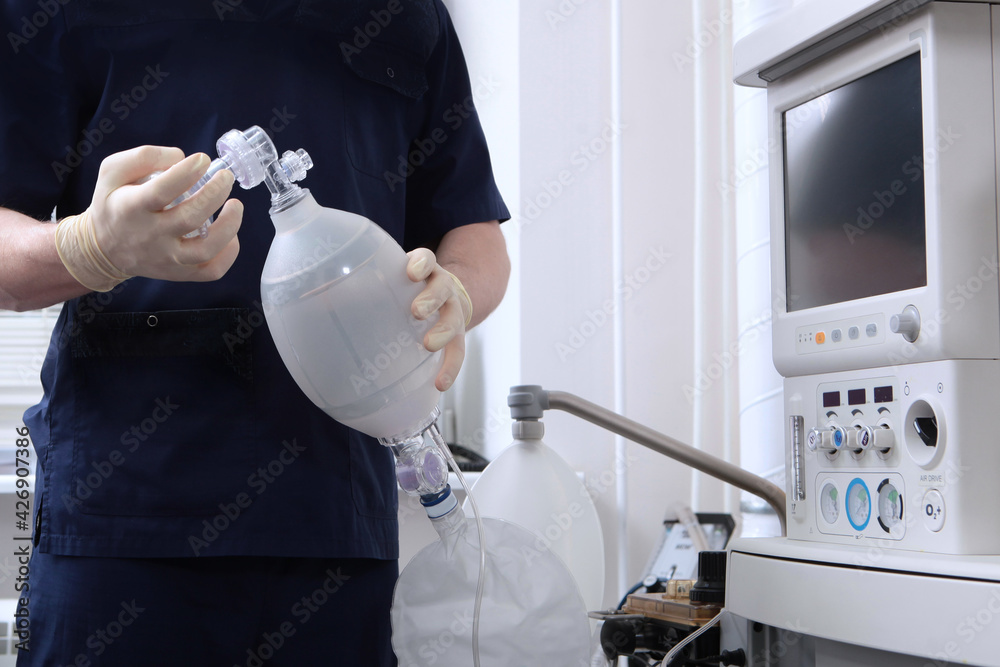 The anesthesiologist holds an ambu bag for ventilation.A spare set of