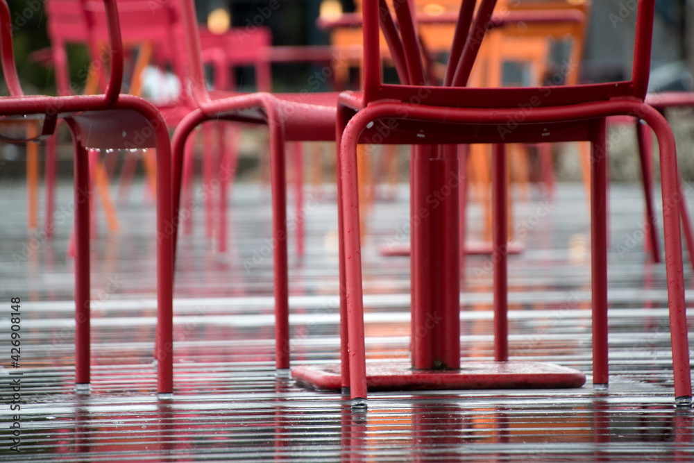 Red and orange furniture in street cafe on a wet deck Red and orange furniture in street cafe on a wet deck