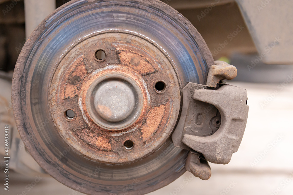 Heavily worn brake disc. Car brake disc after removing the wheel. A rusty disk that needs to be replaced. Heavily worn brake disc. Car brake disc after removing the wheel. A rusty disk that needs to be replaced.