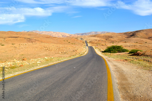 Road rolling through the countryside, view of the desert and mountains in Jordan
